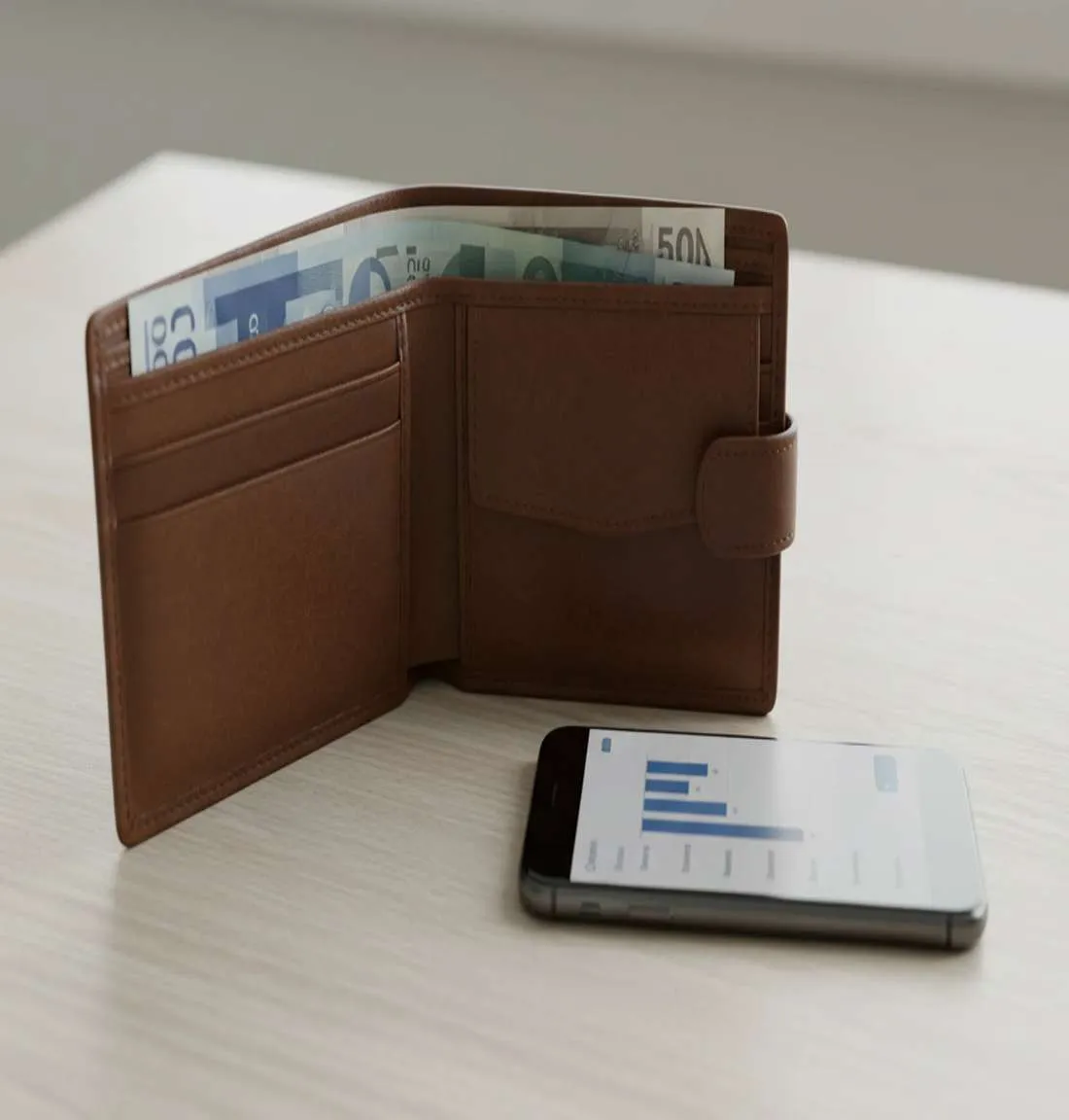 Wallet with currency and smartphone showing finance app representing disciplined money management